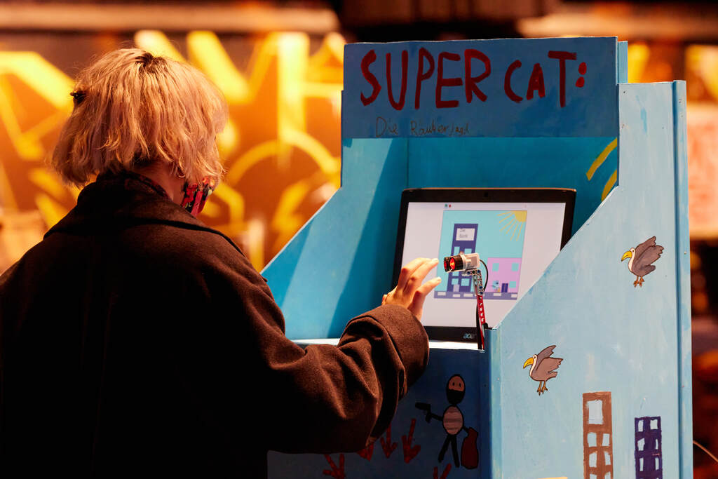 Blonde Person probiert die "Super Cat"Arcade aus